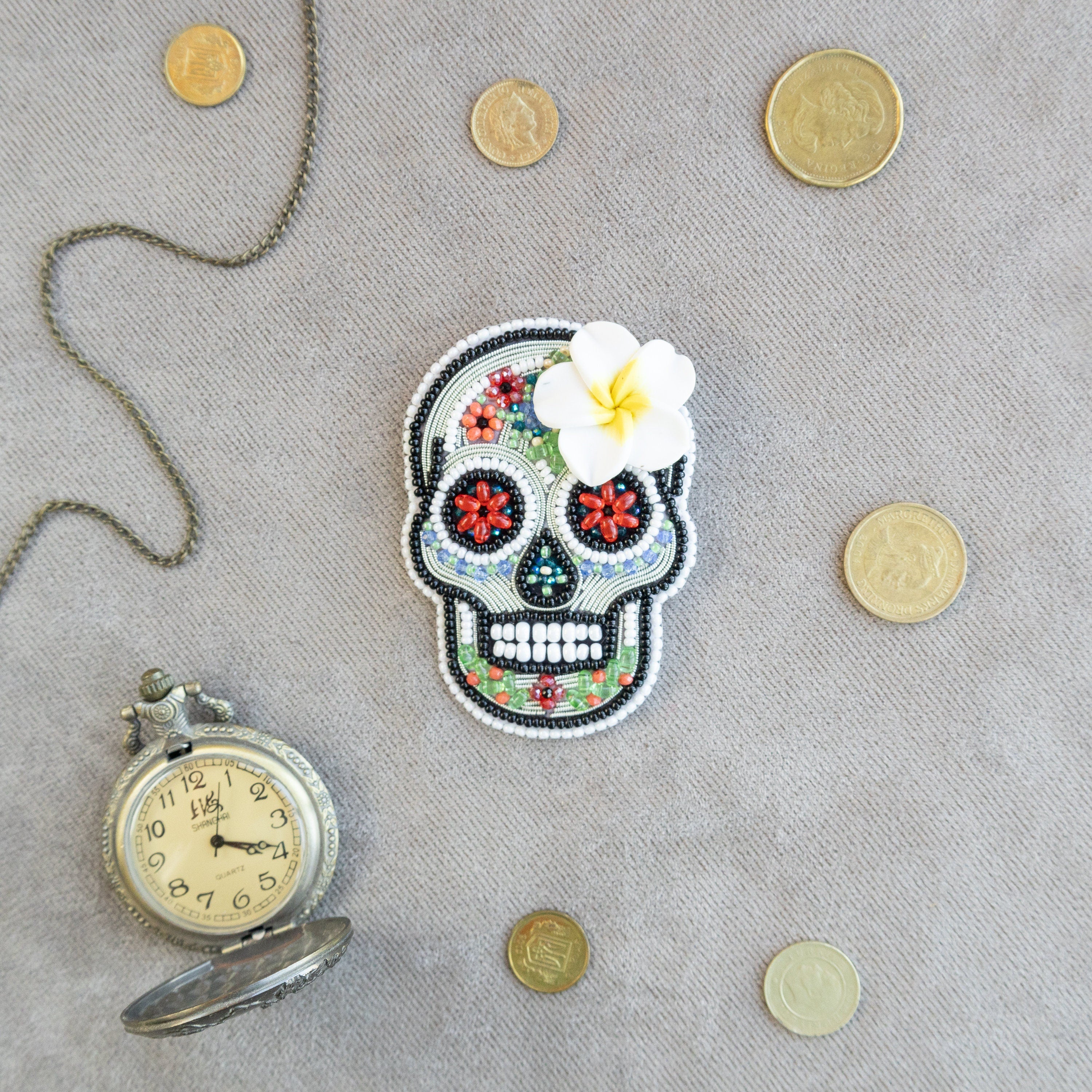 a picture of a skull with a flower and a pocket watch
